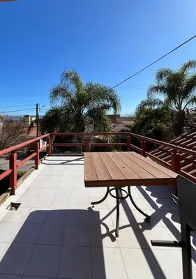 a wooden picnic table sitting on top of a patio at Cabaña Villa Carlos Paz in Villa Carlos Paz
