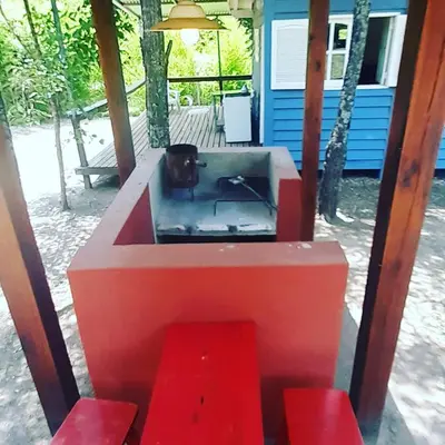 an outdoor grill with red steps in front of a house at Miralrio in Santa Rosa de Calamuchita