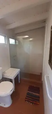 a bathroom with a toilet and a bench and a tub at Miralrio in Santa Rosa de Calamuchita