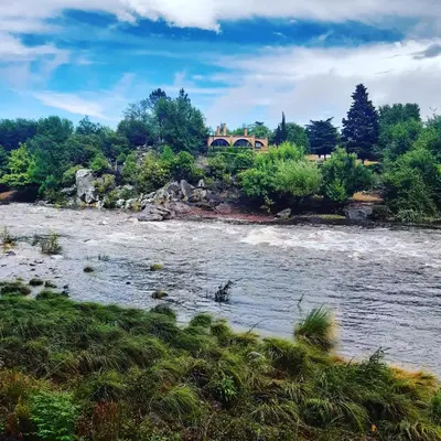 a view of a river with a bridge in the background at Miralrio in Santa Rosa de Calamuchita