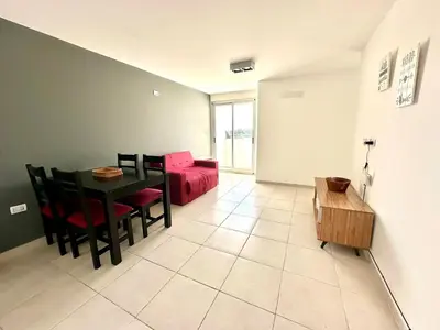 a living room with a table and a red couch at Alojamiento para 3 personas in Cordoba