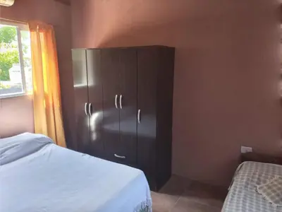 a bedroom with a black cabinet next to a bed at Departamento Los Jacaranda in Villa Carlos Paz