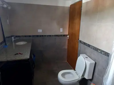 a bathroom with a toilet and a sink at Departamento Los Jacaranda in Villa Carlos Paz