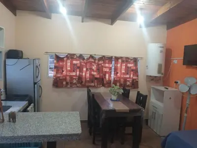 a kitchen with a dining room table and a table and a table at Departamento Los Jacaranda in Villa Carlos Paz