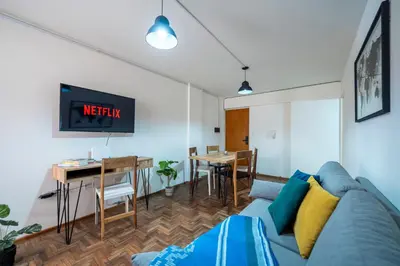 a living room with a blue couch and a table at Moderno y Confortable Depto Zona Universidad - Sanatorio Allende in Cordoba