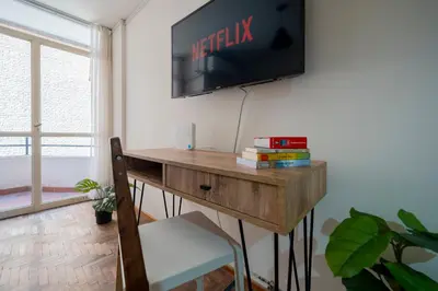 a room with a desk with a television on a wall at Moderno y Confortable Depto Zona Universidad - Sanatorio Allende in Cordoba