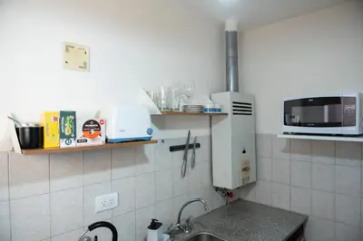 a kitchen with a sink and a microwave at Moderno y Confortable Depto Zona Universidad - Sanatorio Allende in Cordoba