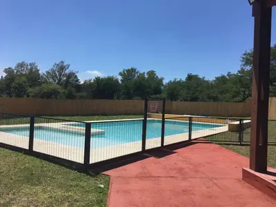 a fence around a swimming pool in a yard at Depto a 10 min de Villa General Belgrano in Villa Ciudad Parque