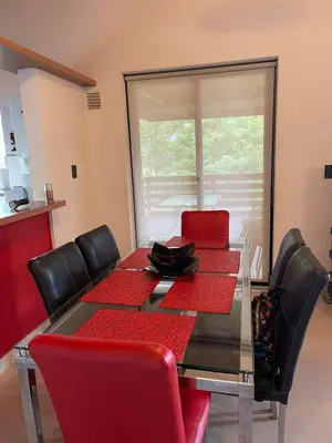 a dining room with a red table and chairs at Depto a 10 min de Villa General Belgrano in Villa Ciudad Parque