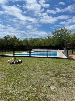a swimming pool in a yard with a fence at Depto a 10 min de Villa General Belgrano in Villa Ciudad Parque