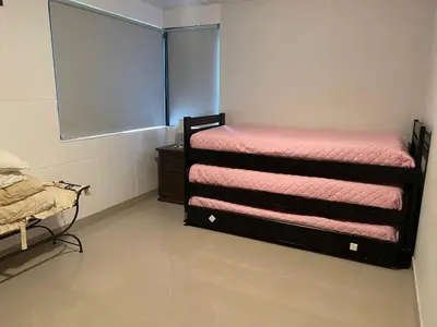 a room with two bunk beds with pink sheets at Depto a 10 min de Villa General Belgrano in Villa Ciudad Parque