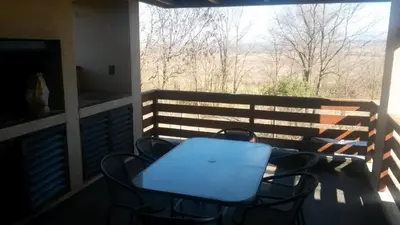 a table and chairs on a balcony with a window at Depto a 10 min de Villa General Belgrano in Villa Ciudad Parque
