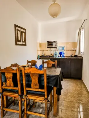 a dining room with a table and chairs and a kitchen at Cabañas Quebrada del Lobito in Villa Santa Cruz del Lago