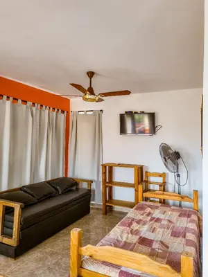 a living room with a couch and a bed at Cabañas Quebrada del Lobito in Villa Santa Cruz del Lago
