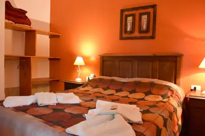a bedroom with a bed with towels on it at Cabañas Quebrada del Lobito in Villa Santa Cruz del Lago