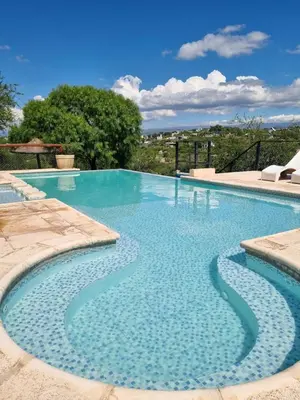 a large swimming pool with blue water at Cabañas Quebrada del Lobito in Villa Santa Cruz del Lago