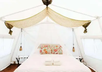 a bedroom with a white bed with a canopy at Glamping Traslasierra Carpa Norte in San Javier
