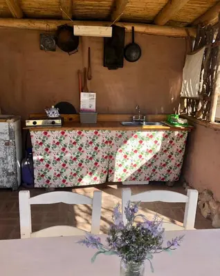 a kitchen with a table and two chairs and a counter at Glamping Traslasierra Carpa Norte in San Javier