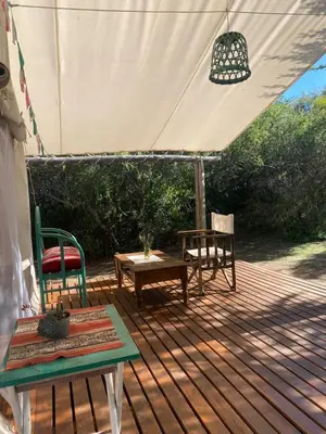 a deck with chairs and a table and a tent at Glamping Traslasierra Carpa Norte in San Javier