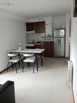 a kitchen with a table and a stainless steel refrigerator at Sueños in Villa Carlos Paz