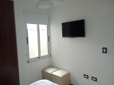 a white room with a television and a window at Sueños in Villa Carlos Paz