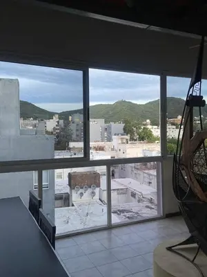 a view of a city from a large window at Sueños in Villa Carlos Paz