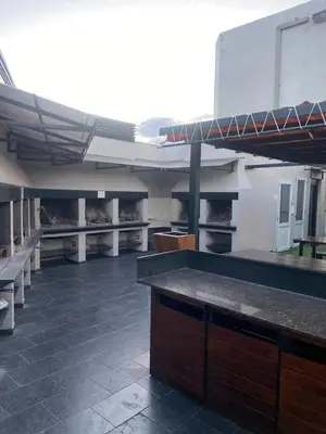 a large kitchen with tables and benches in a building at Sueños in Villa Carlos Paz