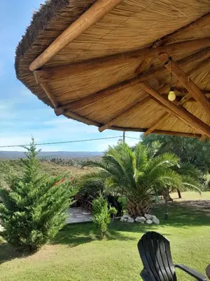 a wooden pavilion with a table and a chair under it at Ayres Serranos in Villa Carlos Paz
