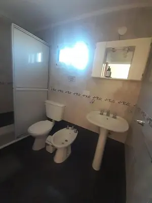 a bathroom with a toilet and a sink and a mirror at Ayres Serranos in Villa Carlos Paz