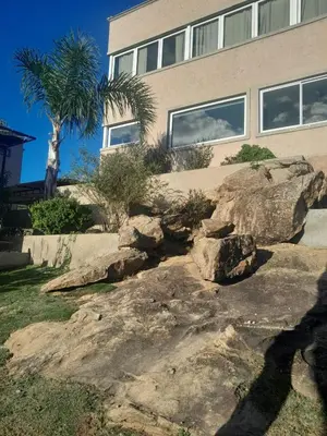 a house with rocks in front of a building at Ayres Serranos in Villa Carlos Paz