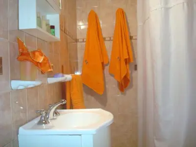 a bathroom with a sink and orange towels at Cabañas Don Esteban in Las Chacras (La Paz)