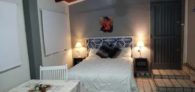 a bedroom with a white bed with two tables and two lamps at Cabañas Don Esteban in Las Chacras (La Paz)