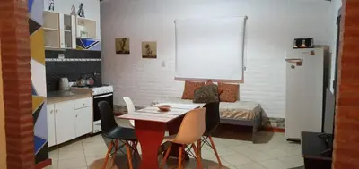 a kitchen with a table and chairs and a bed at Cabañas Don Esteban in Las Chacras (La Paz)