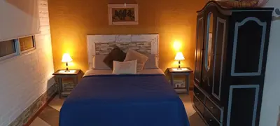 a bedroom with a bed with two lamps on two tables at Cabañas Don Esteban in Las Chacras (La Paz)