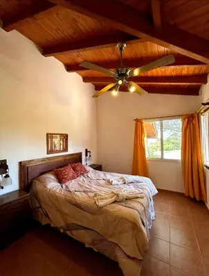 a bedroom with a bed and a ceiling fan at La Rabona Cabañas in Las Rabonas