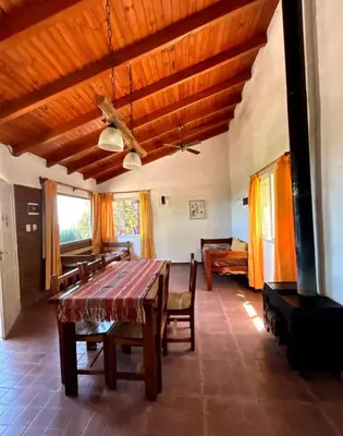 a dining room with a wooden table and chairs at La Rabona Cabañas in Las Rabonas