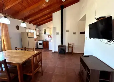 a kitchen and dining room with a table and a television at La Rabona Cabañas in Las Rabonas