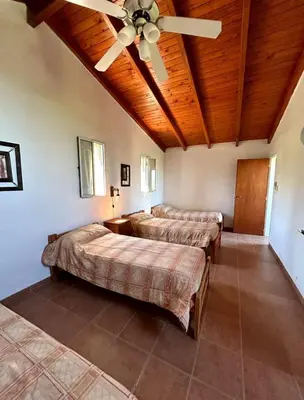a bedroom with three beds and a ceiling fan at La Rabona Cabañas in Las Rabonas