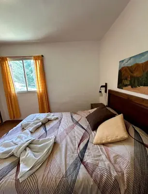 a bedroom with a large bed with clothes on it at La Rabona Cabañas in Las Rabonas