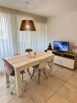 a dining room with a table with chairs and a tv at Harmony Apart in Cordoba