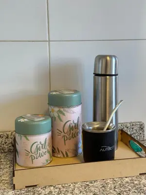 three canisters sitting on a wooden shelf next to a coffee pot at Harmony Apart in Cordoba