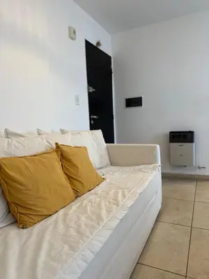 a white couch with two yellow pillows on it at Harmony Apart in Cordoba