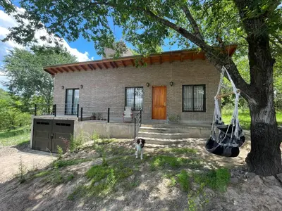 a dog standing in front of a house at Caminito in Los Reartes