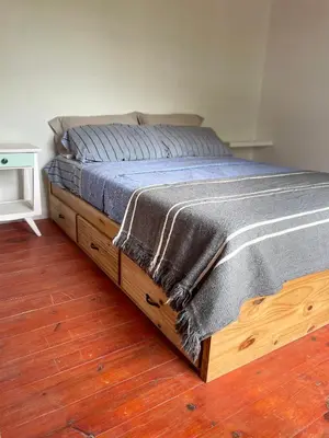 a bed in a bedroom with a wooden floor at Caminito in Los Reartes