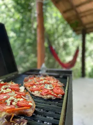 two pizzas are cooking on a grill at Caminito in Los Reartes