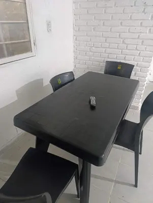 a black table with two chairs and a remote control on it at Departamento nubes in Cordoba