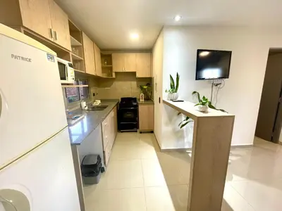 a small kitchen with a counter and a tv on the wall at Nova Urbs in Cordoba