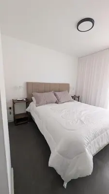 a large white bed in a white bedroom with aigil at Apartamento de un dormitorio, Nueva Córdoba in Cordoba