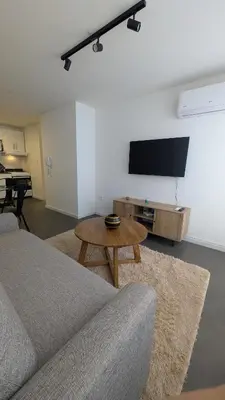 a living room with a couch and a table and a flat screen tv at Apartamento de un dormitorio, Nueva Córdoba in Cordoba