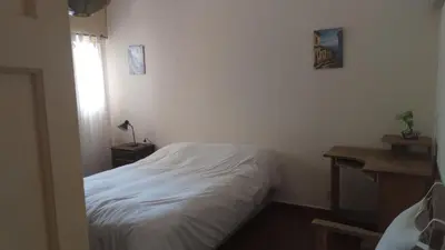 a small bedroom with a white bed and a window at La casa de Mirta Habitaciones en Córdoba in Cordoba
